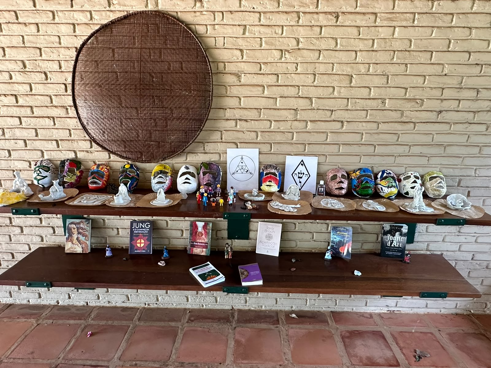Altar coletivo com as máscaras de gesso pintadas, figuras de argila e livros de Jung